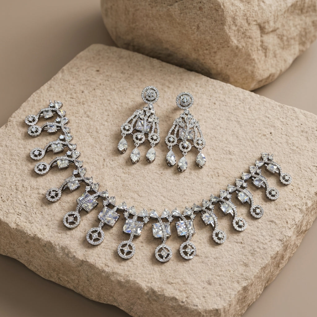 Full necklace and chandelier earring set on a textured stone slab.