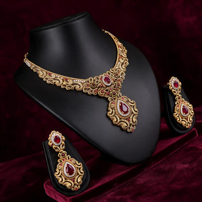 Angled view of the red and gold-tone necklace and earrings showing the open scrollwork design.