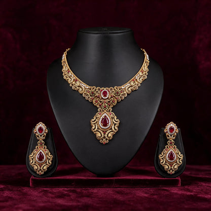 Front view of the Gulnaar necklace and matching earrings on black displays against burgundy fabric.