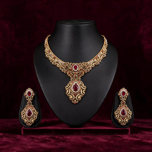 Front view of the Gulnaar necklace and matching earrings on black displays against burgundy fabric.