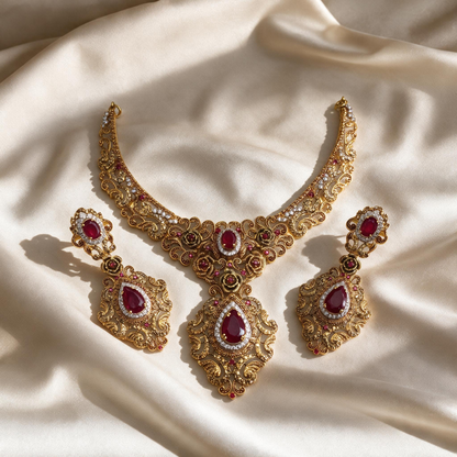 Gulnaar red and gold-tone necklace with two matching drop earrings arranged on ivory fabric.
