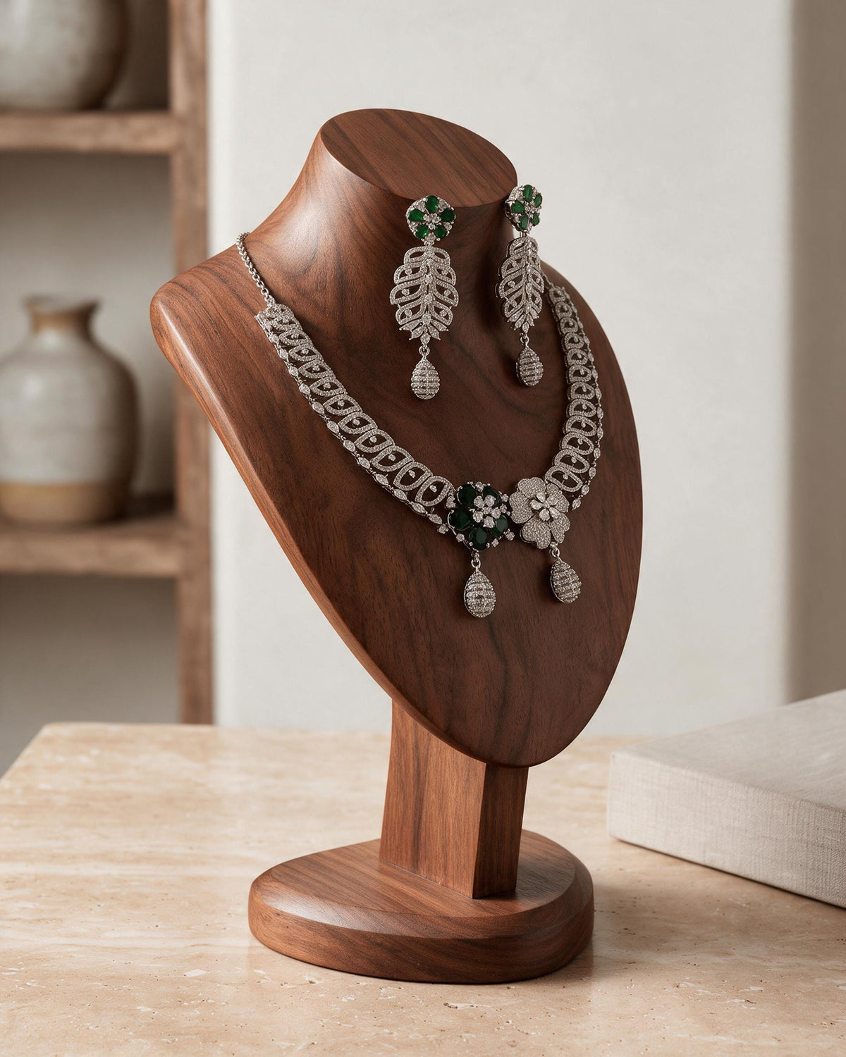 Side view of the Meher necklace and earrings on a wooden bust.