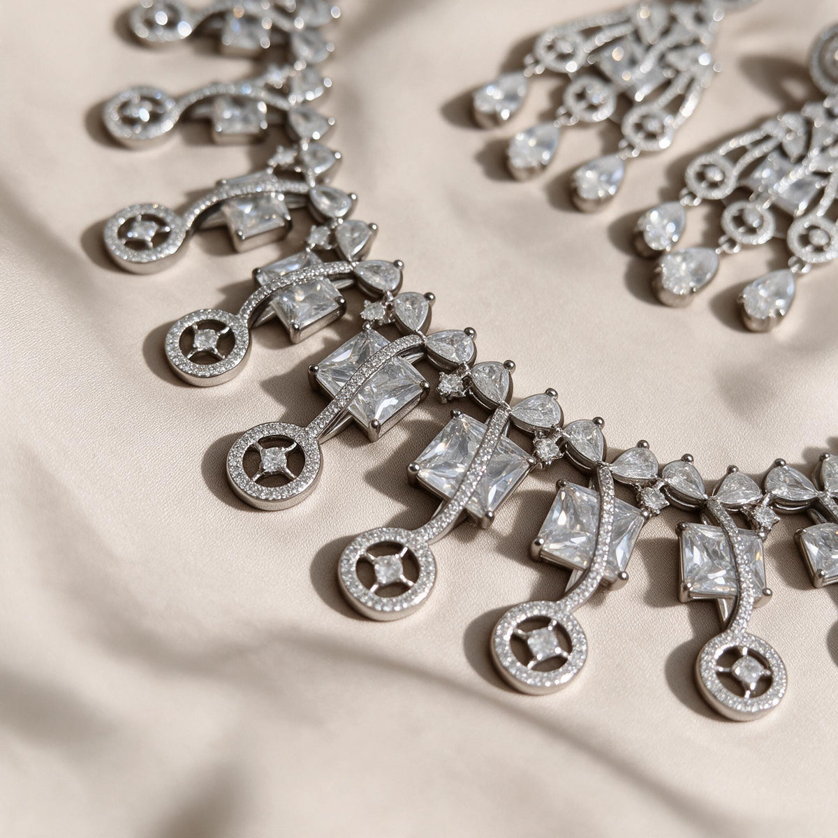 Detail of curved necklace links, clear square accents and open circular drops.